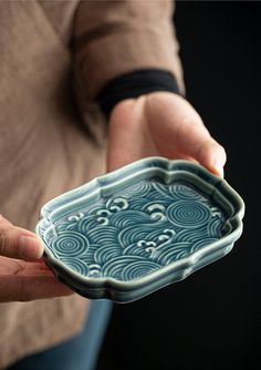 a person holding a blue and white dish in their hands