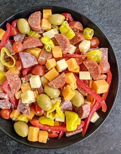 a black bowl filled with lots of different types of food on top of a table