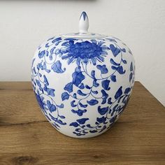 a blue and white vase sitting on top of a wooden table