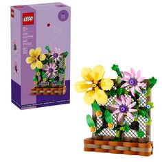 a lego planter with flowers in it next to a box