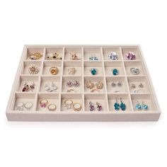 a white tray filled with lots of different types of earrings