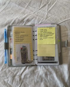 an open notebook with notes and pens on it