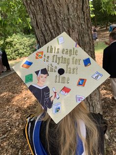 a woman wearing a graduation cap that says, this eagle is flying for the last time