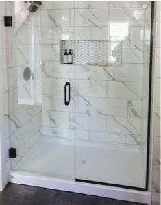 the shower door is glass and has black handles