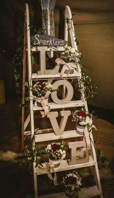 a ladder decorated with flowers and greenery