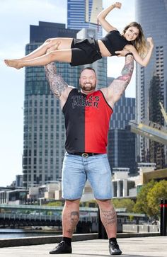 a man and woman doing acrobatic tricks in front of a city skyline