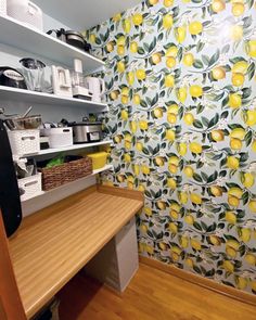 a kitchen with yellow lemons on the wall and wooden counter top, along with shelves