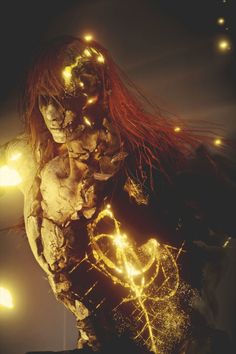 a woman with red hair and glowing lights on her face, standing in front of a dark background