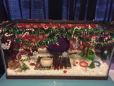 a christmas display with candy canes and other holiday decorations in it's glass case