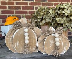 two decorative pumpkins sitting on top of a wooden table