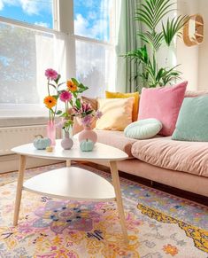 a living room filled with lots of furniture and flowers in vases on the coffee table