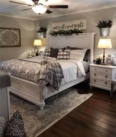 a white bed sitting in a bedroom on top of a hard wood floor next to two lamps