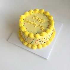 a birthday cake with yellow frosting and sprinkles