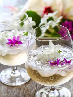 two glasses filled with white wine and flowers