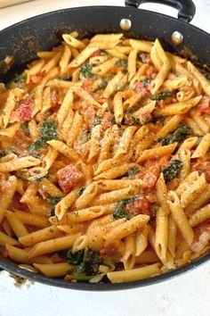 a pan filled with pasta and sauce on top of a table