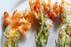 three asparagus with orange and white stuff on them