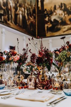 there are many vases with flowers in them on the table at this wedding reception