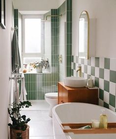 a bathroom with green and white tiles on the walls