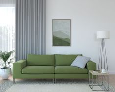 a living room with a green couch and white rug