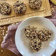 cookies and oatmeal on a plate next to a cutting board with bananas