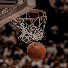 a basketball going through the hoop in front of an audience