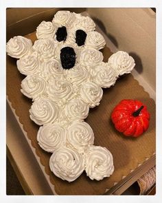 a cake in the shape of a teddy bear with white frosting and black eyes