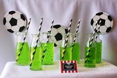 soccer themed drinking glasses and paper straws with green liquid in them on a table