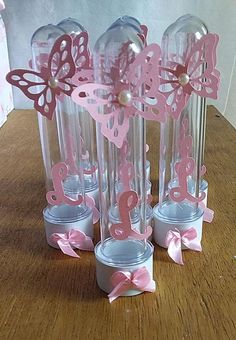 there are several vases with butterflies on them and pink bows around the top one