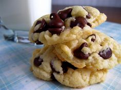 three chocolate chip cookies stacked on top of each other next to a glass of milk