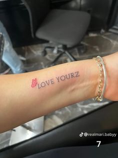 a woman's arm with the words love yourz tattooed on her left arm