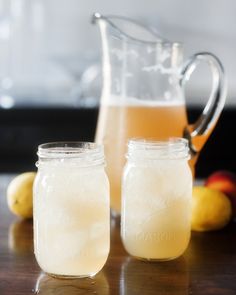 two mason jars filled with lemonade sit on a table