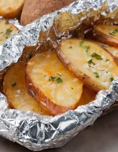 baked potatoes in foil with parsley on top