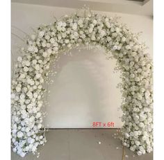 the white flowers are arranged in an arch