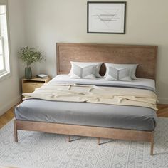 a bed with two pillows on top of it in a bedroom next to a window