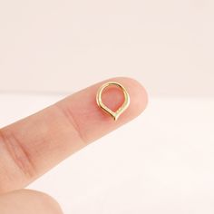 a person's finger with a gold ring on top of their thumb and the middle finger is pointed toward the camera