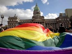 a large rainbow colored kite in front of a building