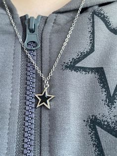 a close up of a person wearing a necklace with a star on it