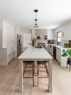 a kitchen with white cabinets and wooden floors