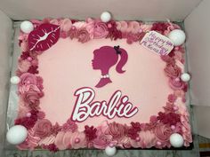 a birthday cake decorated with pink frosting and white icing, featuring a silhouette of a woman's head