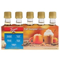 four bottles of pumpkin spice flavored fall sampleer syrups on a white background