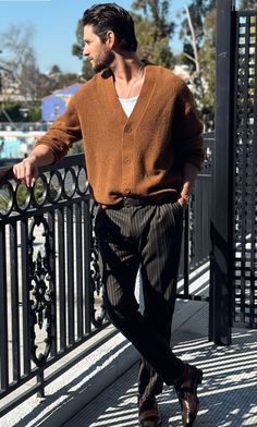 a man walking down a street next to a fence