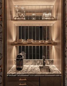 a kitchen with marble counter tops and wooden cabinetry, along with shelves that have glass containers on them