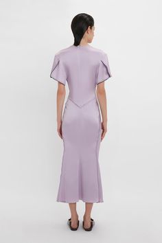 Elegant midi dresses are a hallmark of the Victoria Beckham brand. Crafted in a figure-flattering stretch fabric, this V-neck midi dress in romantic Petunia has a soft curved neckline and waist-defining pleat detail. Draped short sleeves with exposed seams and contrasting navy topstitching inject directional talking points, while a longer-length hem to the back enhances the fluidity of this modern classic. Victoria Beckham Gathered V-Neck Midi Dress In Petunia  - Size 12 UK Elegant Fitted V-neck Dress For Daywear, Structured Boning Midi Dress With Fitted Bodice, Spring Midi Dress With Structured Boning, Spring Fitted Midi Dress With Structured Boning, Fitted Bodice Midi Dress With Bias Cut, Fitted Midi Dress With Structured Boning For Spring, Fitted Bodice Bias Cut Midi Dress, Elegant V-neck Midi Dress For Daywear, Bias Cut Midi Dress With Fitted Bodice