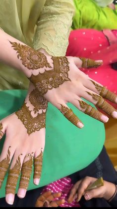 two hands with henna tattoos on them