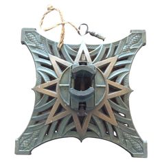 an ornate metal object hanging from a rope