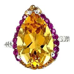 This gorgeous ring has a magnificent Pear Cut Citrine Quartz weighing 5.28 Carats and is surrounded by 25 Pink and Yellow Sapphires that weigh 0.60 carats and 20 Round Cut Diamonds that weigh 0.37 carats. (Clarity: SI, Color: F) The total carat weight of the ring is 6.25 carats. Each stone is handpicked and carefully curated to create a unique piece by our in-house designer and jeweler! The Citrine measures approximately at 11 mm x 16 mm. It is set in 14K White Gold and weighs approximately 3.8 Gold Cocktail Ring, Gold Cocktail, Pink And Yellow, Yellow Sapphire, Sapphire Diamond, Pear Cut, Cocktail Ring, Round Cut Diamond, Pink Sapphire