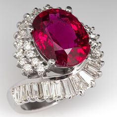 an oval shaped ruby and diamond ring with baguets around it's sides