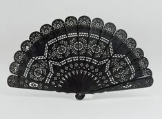 a black and white hand fan sitting on top of a table