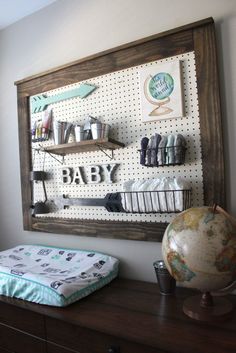 a baby's room with a map, bookshelf and other items on the wall