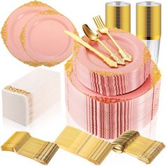 a pink cake with gold trimmings and plates